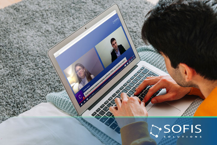 Man in front of a computer watching a webinar